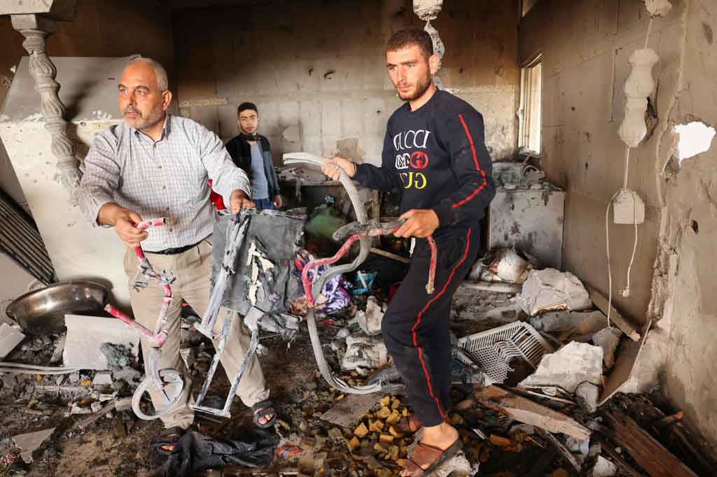 Kerabat memeriksa kerusakan di sebuah rumah di Deir el-Balah, Jalur Gaza tengah, pada Rabu, 19 Mei 2021, di mana Iyad, seorang pria disabilitas bersama istrinya yang sedang hamil dan putrinya yang berusia 3 tahun meninggal dalam serangan udara Israel.