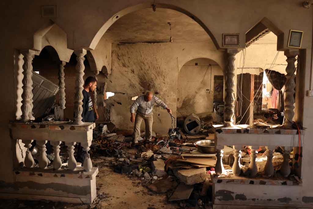 Ruang tamu rumah tersebut hancur berkeping-keping dan bagian-bagian sepeda merah seorang anak yang hancur tergeletak di tengah reruntuhan. Di dalam lemari es mereka yang roboh, debu abu-abu menutupi semangkuk tomat merah segar.