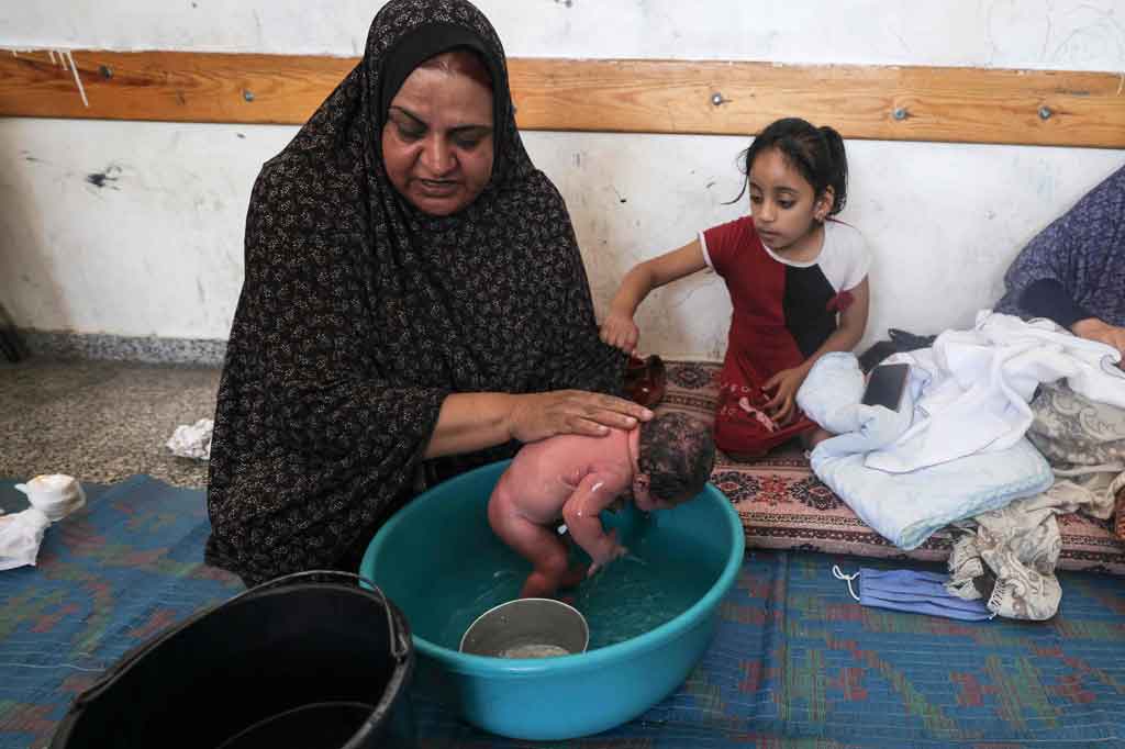 Ansam al-Safadi, ibu Mohammed, mengatakan dia tidak pernah berpikir akan menyambut bayi laki-lakinya di ruang kelas yang dihuni oleh keluarga lain.

 Setelah melahirkan di Rumah Sakit al-Awda, Ansam kembali ke sekolah beberapa jam kemudian.
 “Ini situasi yang sulit. Akhir kehamilan saya diwarnai dengan keadaan ketakutan dan panik. Di sini, tidak ada privasi, dan kami bahkan tidak punya tempat tidur bayi untuk Mohammed,