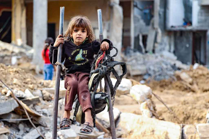 Seorang anak perempuan Palestina duduk di tengah puing-puing di lingkungannya yang dilanda pemboman Israel di Kota Gaza.