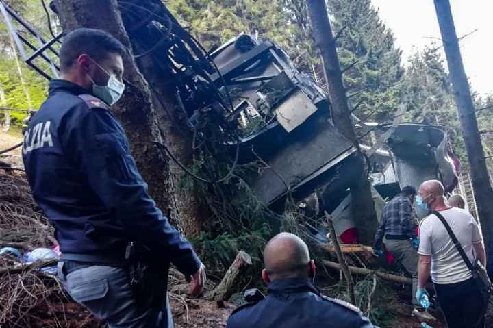 Gambar dari Kepolisian Italia menunjukkan puing-puing dari kabin kereta jatuh di tengah hutan dan lereng curam, sehingga menyulitkan proses evakuasi.