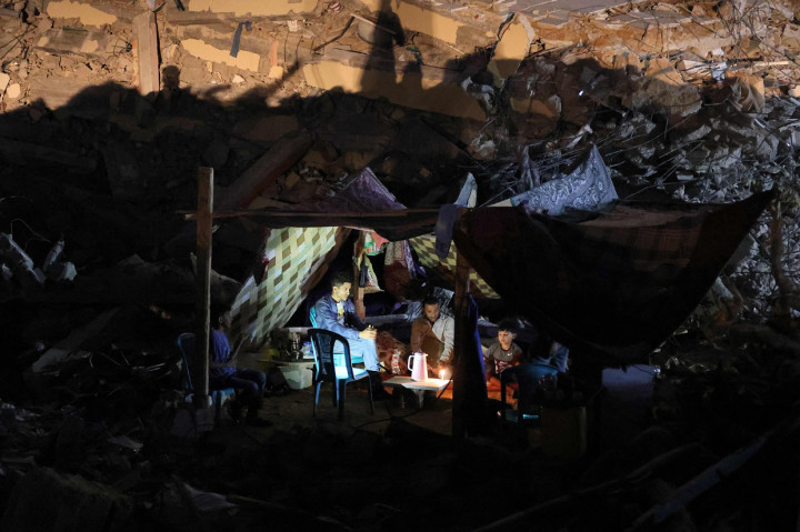 Warga Palestina duduk di tenda yang didirikan di atas reruntuhan bangunan yang hancur dalam serangan udara Israel di Kota Gaza, 24 Mei 2021.