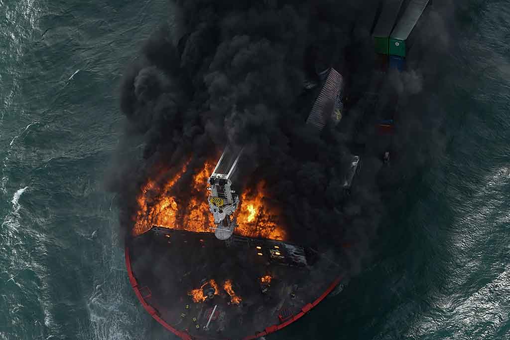 Angin kencang yang terkait dengan topan yang menghantam India timur menghambat upaya untuk memadamkan kobaran api saat asap hitam membubung dari MV X-Press Pearl.