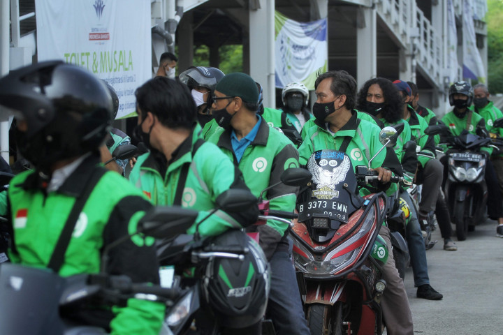 Sejumlah pengemudi ojek online mengantre untuk menerima vaksin di Sentra Vaksinasi, RSUI, Depok, Jawa Barat.