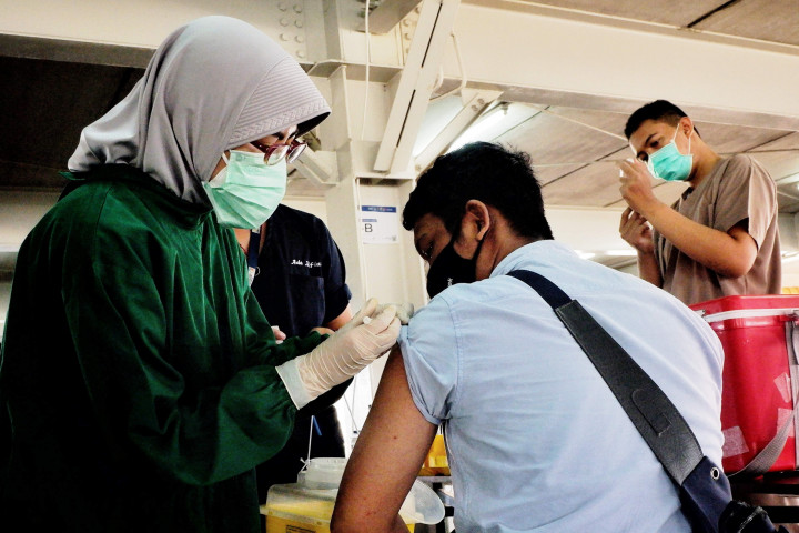 Tenaga kesehatan memberikan vaksin pada pengemudi ojek online di Sentra Vaksinasi, RSUI, Depok, Jawa Barat.