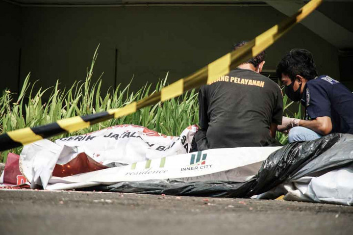 Petugas mengidentifikasi jenazah pria di area parkir Apartemen Metro Park Residence, Kedoya, Jakarta Barat, Rabu, 2 Juni 2021. 