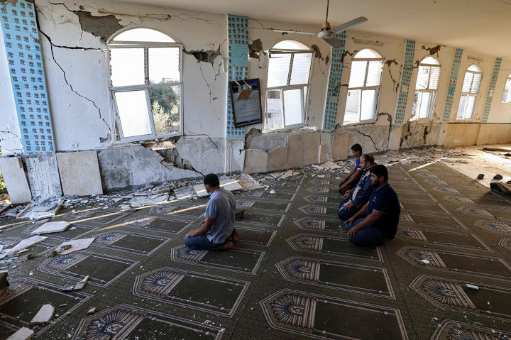 Warga Palestina melaksanakan salat di masjid yang hancur selama konflik antara Hamas dan Israel pada Mei 2021 di Beit Lahia, Jalur Gaza, Senin, 7 Juni 2021.
