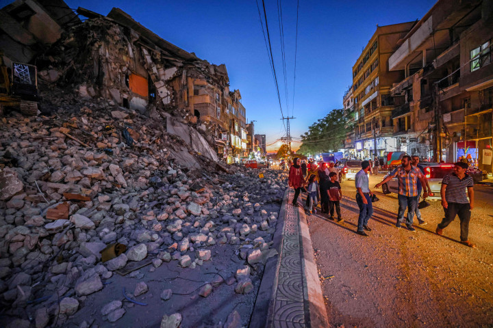 Warga Palestina berkumpul dekat reruntuhan bangunan yang hancur selama konflik antara Hamas dan Israel pada Mei 2021 di Beit Hanun, Jalur Gaza, Senin, 7 Juni 2021.
