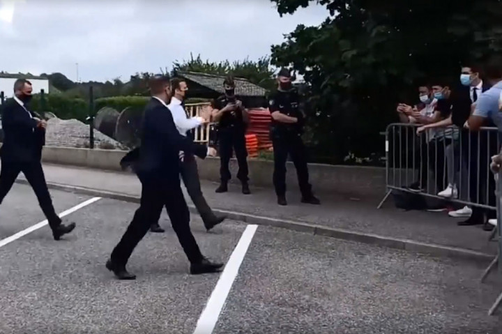 Macron kemudian menyapa warga yang berada di luar pagar pembatas.