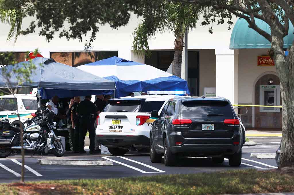 Petugas Sheriff Palm Beach County berdiri di luar supermarket Publix di mana seorang perempuan, anak-anak dan seorang pria ditemukan tewas dengan luka tembak di Royal Palm Beach, Florida pada Kamis, 10 Juni 2021 waktu setempat.