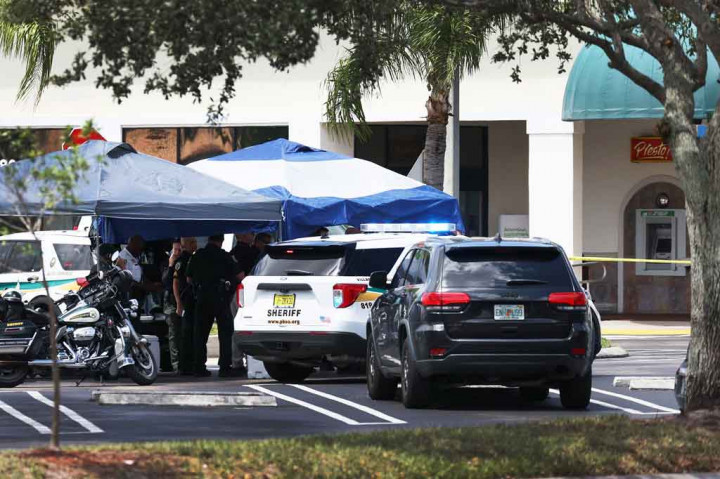 Petugas Sheriff Palm Beach County berdiri di luar supermarket Publix di mana seorang perempuan, anak-anak dan seorang pria ditemukan tewas dengan luka tembak di Royal Palm Beach, Florida pada Kamis, 10 Juni 2021 waktu setempat.