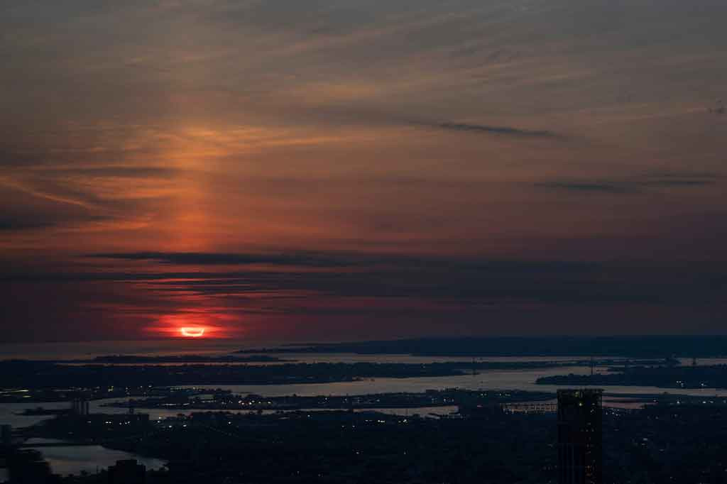 Fase gerhana matahari cincin tertutup awan terlihat di Kota Jersey, New Jersey, Amerika Serikat.