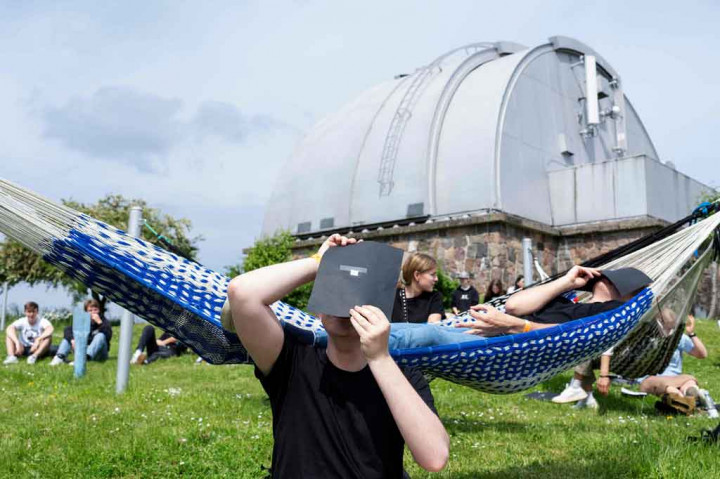 Warga melihat fenomena gerhana matahari cincin dengan kaca filter di Observatorium Brorfelde, Tollose, Denmark.