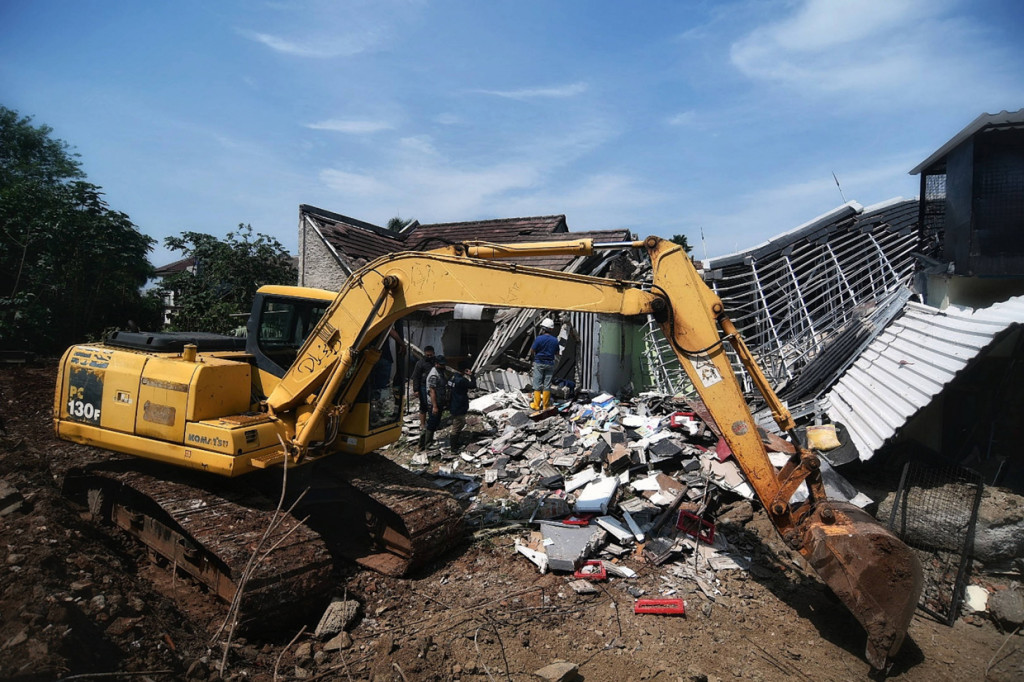 Terlihat alat berat diturunkan untuk mengevakuasi puing-puing yang runtuh. 