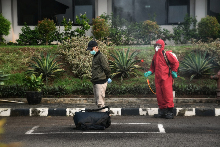 Pasien terkonfirmasi positif covid-19 disemprot disinfektan saat tiba untuk menjalani isolasi di Graha Wisata Ragunan, Jakarta.
