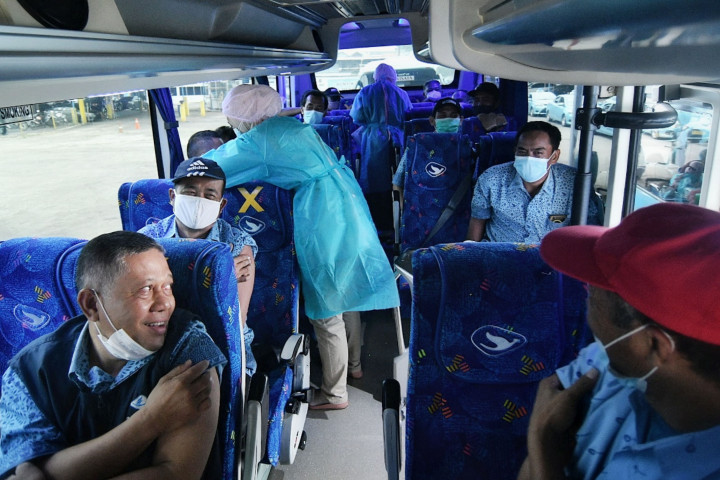 Tenaga medis menyuntikan vaksin Covid-19 kepada pekerja transportasi umum secara lantatur (layanan tanpa turun dari kendaraan) di Pool Bluebird Kramat Jati.