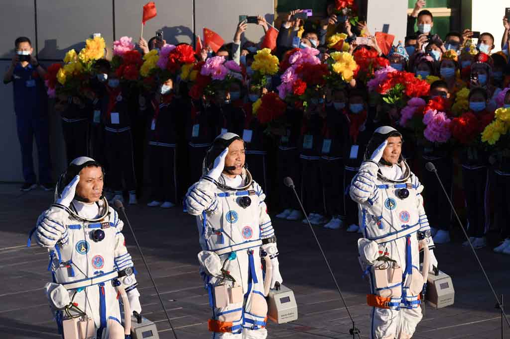 Astronaut Nie Haisheng (tengah), Liu Boming (kanan) dan Tang Hongbo memberi hormat selama upacara keberangkatan sebelum menaiki pesawat ruang angkasa Shenzhou-12 dengan roket pembawa Long March-2F di Pusat Peluncuran Satelit Jiuquan di gurun Gobi, di barat laut Tiongkok pada Kamis, 17 Juni 2021.