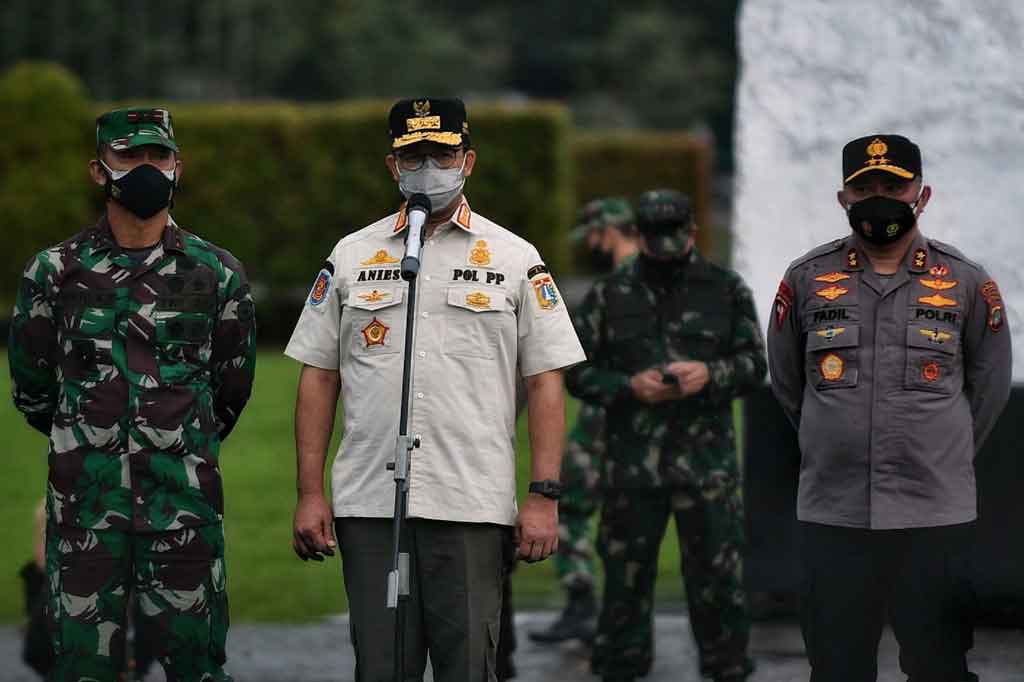 Gubernur DKI Jakarta Anies Baswedan (tengah) didampingi Pangdam Jaya Mayjen Mulyo Aji (kiri) dan Kapolda Metro Jaya Irjen Fadil Imran (kanan) memberikan pengarahan kepada pasukan tiga pilar TNI, Polisi, dan Satpol PP di Lapangan Monumen Nasional, Jakarta, Jumat, 18 Juni 2021.