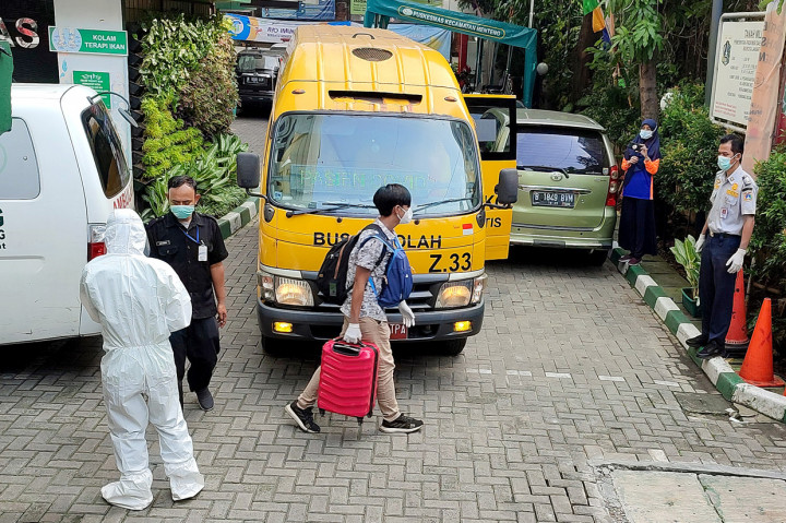 Pasien Covid-19 bersiap memasuki bus sekolah untuk menuju Rumah Sakit Darurat Covid-19 (RSDC) Wisma Atlet Kemayoran di Puskesmas Menteng, Jakarta. 