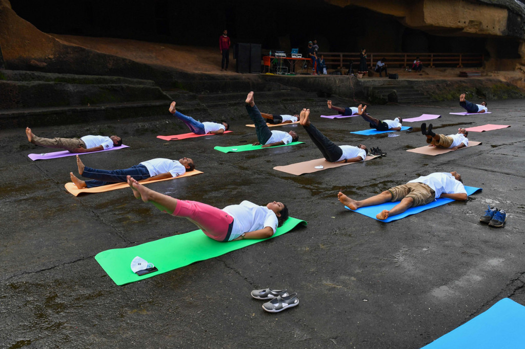 Orang-orang mengikuti sesi yoga di Gua Kanheri di pinggiran Mumbai pada 21 Juni 2021, untuk menandai Hari Yoga Internasional.