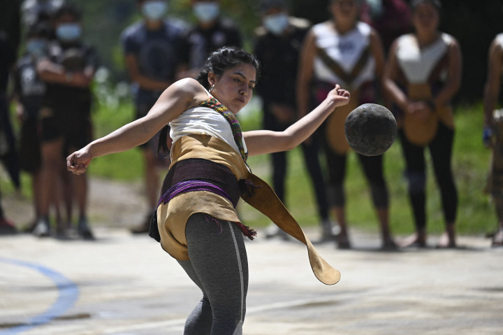Seorang perempuan yang merupakan penduduk lokal Guatemala berpartisipasi dalam permainan bola Maya di viallage Xesampual di Santa Lucia Utatlan, Guatemala, pada 20 Juni 2021.

