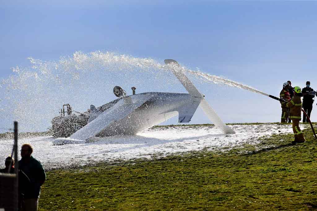 Petugas pemadam kebakaran menyemprotkan busa ke badan pesawat ringan yang jatuh di Morrabbin, pinggiran Melbourne, pada Selasa, 22 Juni 2021. Kecelakaan tersebut melukai pilotnya.
