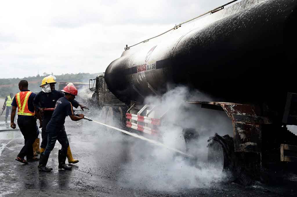 Petugas pemadam kebakaran berusaha memadamkan api yang melalap sebuah truk tangki bahan bakar di antara 11 truk yang terbakar setelah kecelakaan di Ogere, Lagos, Selasa, 22 Juni 2021 waktu setempat.
