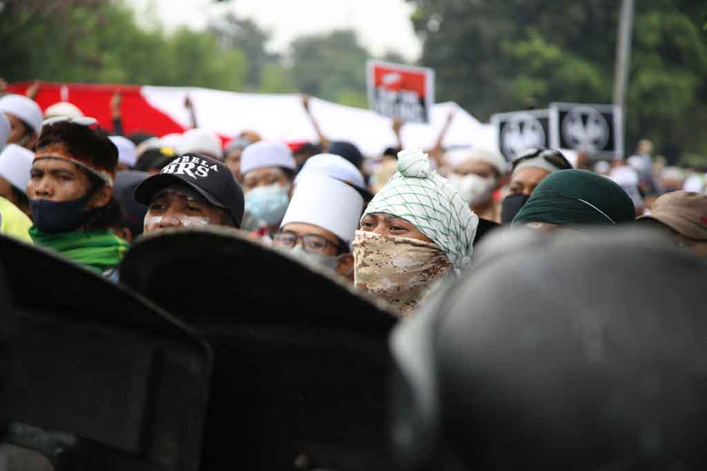 Polisi memblokade massa pendukung Muhammad Rizieq Shihab di kawasan I Jalan Gusti Ngurah Rai saat akan menuju Pengadilan Negeri (PN) Jakarta Timur, Kamis, 24 Juni 2021. 