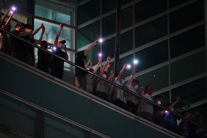 Lepas tengah malam, ketika seluruh eksemplar surat kabar Apple Daily hari ini diproduksi, sejumlah staf surat kabar itu keluar dari dalam gedung. 