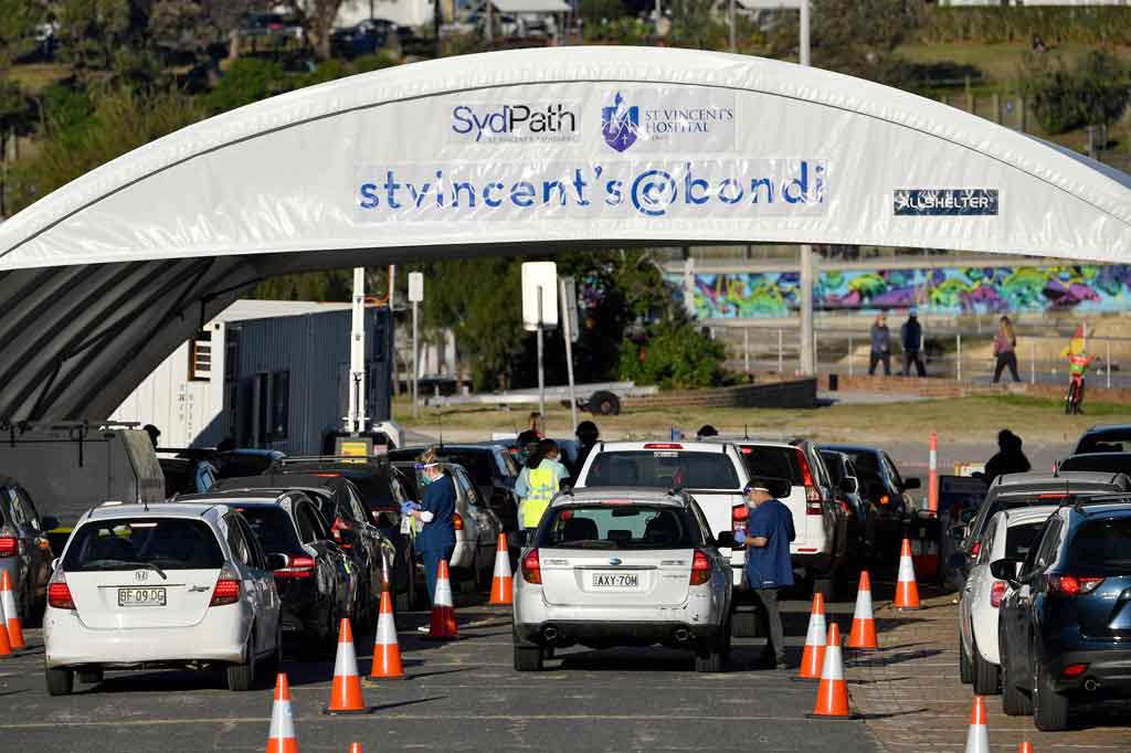 Petugas kesehatan mendaftarkan orang untuk tes covid-19 secara drive thru di Pantai Bondi, Sydney pada Jumat, 25 Juni 2021, ketika pihak berwenang melakukan lockdown beberapa area pusat kota terbesar di Australia untuk menahan wabah varian Delta yang sangat menular.