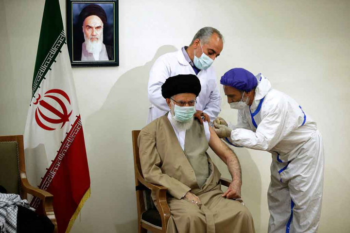 Rekaman itu menunjukkan Ali Khamenei mengenakan masker bedah dan sorban hitam, duduk di bawah gambar pendiri republik Islam Ayatollah Rouhollah Khomeini, saat dua petugas medis pria menyuntiknya di lengan kiri.