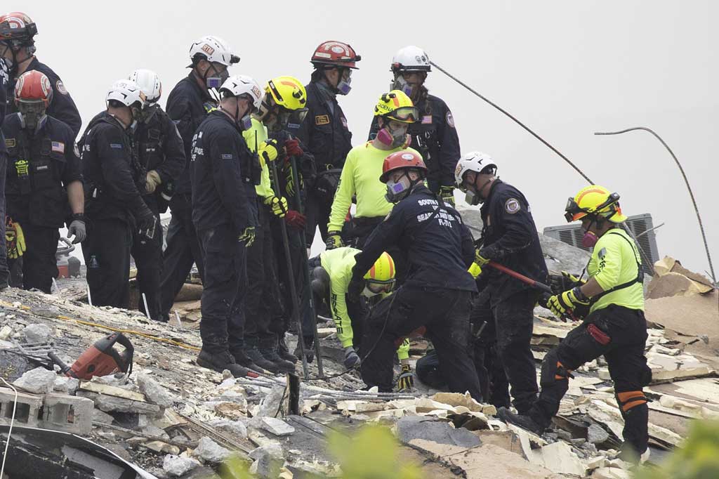 Meski begitu, tim pencarian dan penyelamatan bekerja sepanjang waktu melalui gunungan puing yang tidak stabil, mencari tanda-tanda kehidupan dari 159 orang yang masih belum ditemukan, sementara api yang membara memenuhi udara dengan asap.