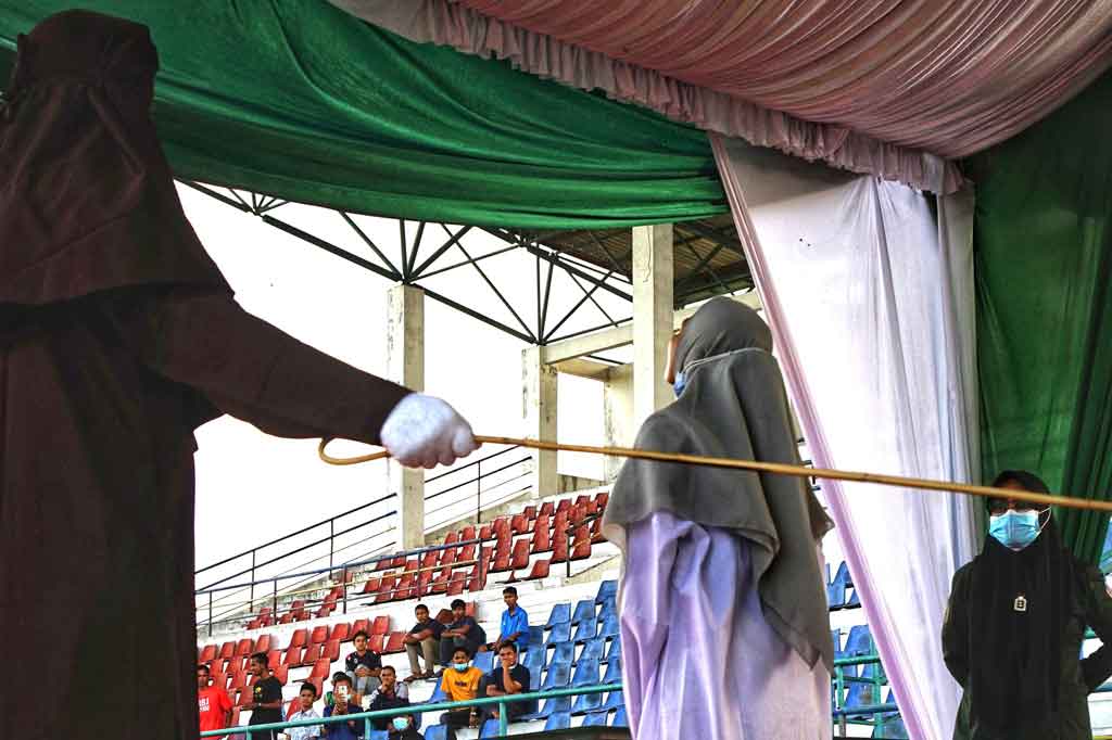 NA, terpidana pelanggar hukum syariat Islam menjalani hukuman cambuk di Taman Bustanulssalatin Banda Aceh, Aceh, Senin, 28 Juni 2021.