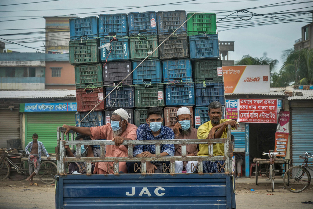Para pekerja migran dan warga lainnya, Senin, 28 Juni 2021, bersiap pulang ke desa asal mereka setelah otoritas berwenang Bangladesh bersiap menerapkan penguncian ketat untuk menahan laju penyebaran Covid-19 di Dhaka, ibu kota Bangladesh. Akibat kesulitan angkutan umum, mereka memilih naik truk dan sepeda motor serta menyewa ambulans.