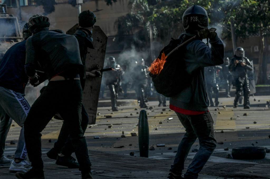 Demonstran bentrok dengan polisi antihuru-hara selama protes terhadap pemerintah di Medellin, Kolombia.