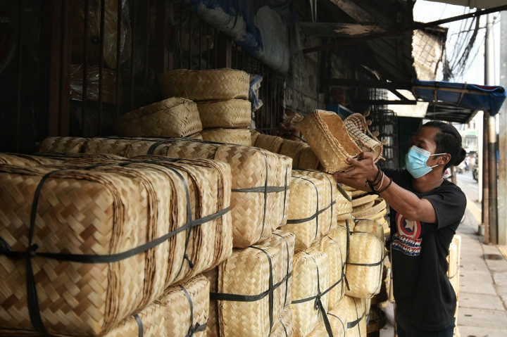Pekerja menata besek di tempat penjualan kerajinan bambu di kawasan Jatinegara, Jakarta.