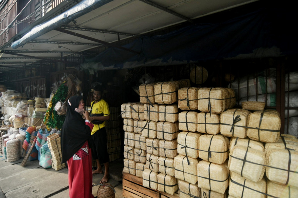 Pedagang melayani pembeli di tempat penjualan kerajinan bambu di kawasan Jatinegara, Jakarta.