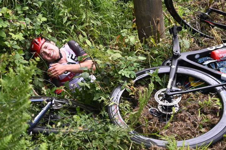 Mengenakan mantel kuning cerah, perempuan tersebut terlihat membentangkan papan karton tulisan tangan ke arah kamera televisi dengan kata-kata 'Allez Opi-Omi!' ('Pergilah, Kakek dan Nenek') di depan para pengendara sepeda, Sabtu, 26 Juni 2021.