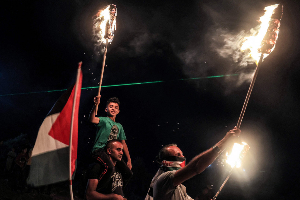 Pengunjuk rasa Palestina menggunakan obor laser selama demonstrasi menentang pos pemukim Israel di Eviatar, di kota Beita, dekat kota Nablus, Tepi Barat, pada 3 Juli 2021.