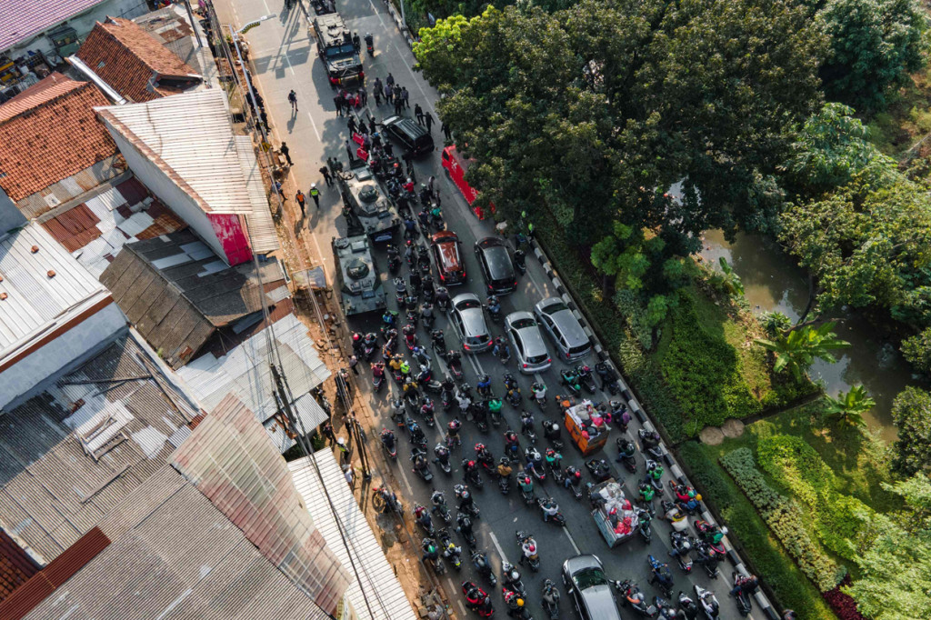 Puluhan kendaaan motor dan mobil dihadang dengan dua kendaraan taktis jenis panser milik TNI yang disiagakan di pos penyekatan perbatasan Depok dan Jakarta di Jalan Lenteng Agung, Jakarta Selatan, Selasa, 6 Juli 2021.