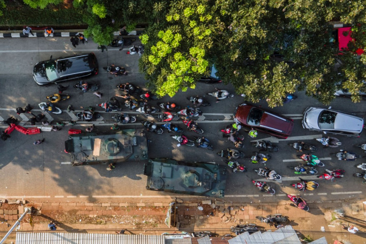 Puluhan kendaaan motor dan mobil dihadang dengan dua kendaraan taktis jenis panser milik TNI yang disiagakan di pos penyekatan perbatasan Depok dan Jakarta di Jalan Lenteng Agung, Jakarta Selatan, Selasa, 6 Juli 2021.