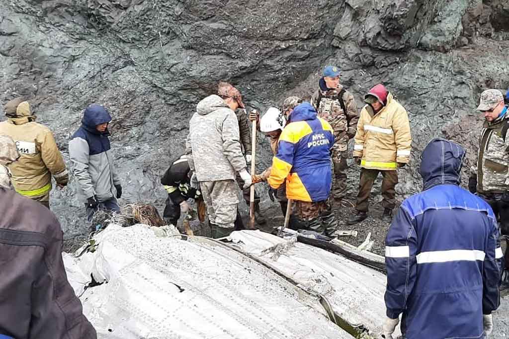 Pekerja Kementerian Situasi Darurat berada di sekitar puing-puing pesawat Antonov An-26 yang ditemukan di dekat bandara tujuannya di luar kota Palana, di Timur Jauh Rusia. 