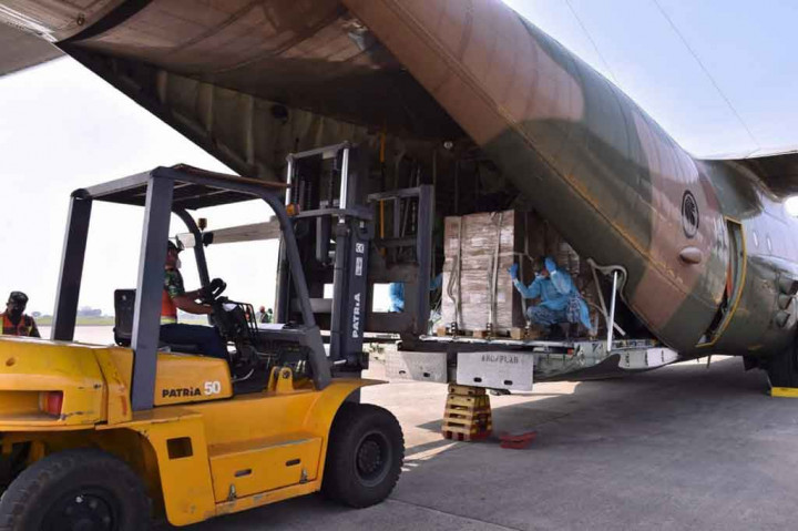 Petugas menurunkan peralatan medis, seperti tabung oksigen, ventilator serta masker, sarung tangan, dan APD dari pesawat Angkatan Udara Singapura di Pangkalan Angkatan Udara Halim Perdanakusuma, Jakarta, Jumat, 9 Juli 2021.