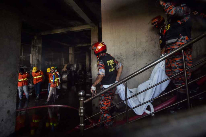 Petugas pemadam kebakaran dan tim penyelamat mengevakuasi jenazah korban  dalam kebakaran yang terjadi sehari sebelumnya di sebuah pabrik minuman dan makanan di Rupganj, Distrik Narayanganj, Bangladesh pada Jumat, 9 Juli 2021.