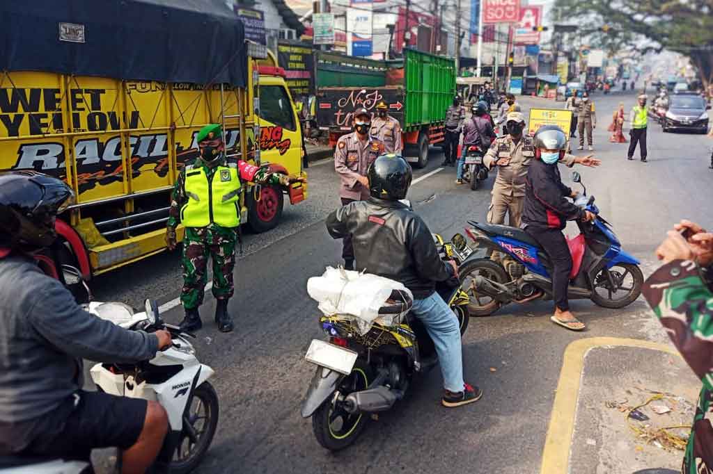 Petugas memutar balik kendaraan motor maupun mobil dengan plat no B sementara kendaraan dengan plat F diperbolehkan meneruskan perjalanan memasuki wilayah Bogor.