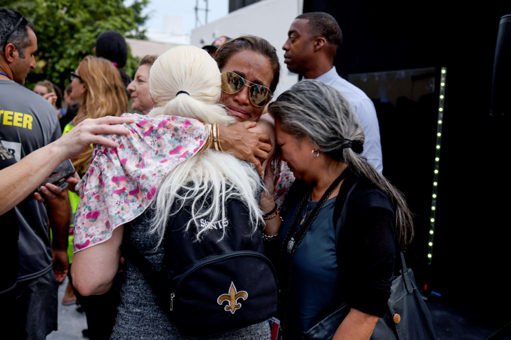 Para pelayat berpelukan saat pelepasan Unit Penyelamatan Nasional Pasukan Pertahanan Israel (IDF) pada 10 Juli 2021 di Surfside, Florida.