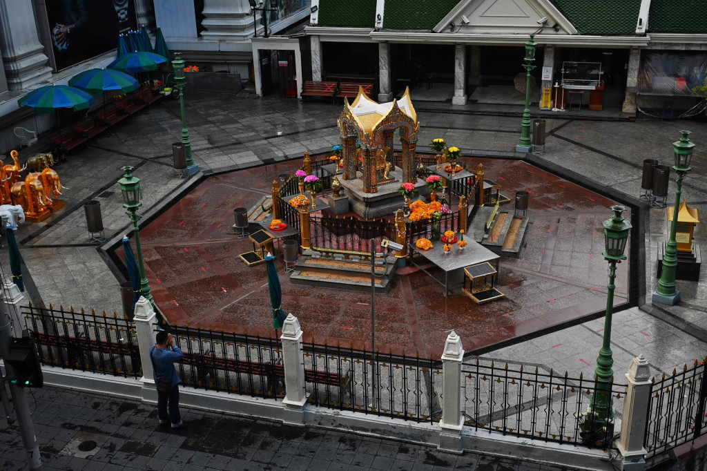 Seorang pria berdoa di luar gerbang Kuil Erawan pada hari pertama penguncian Covid-19 yang lebih ketat di Bangkok, Senin, 12 Juli 2021.