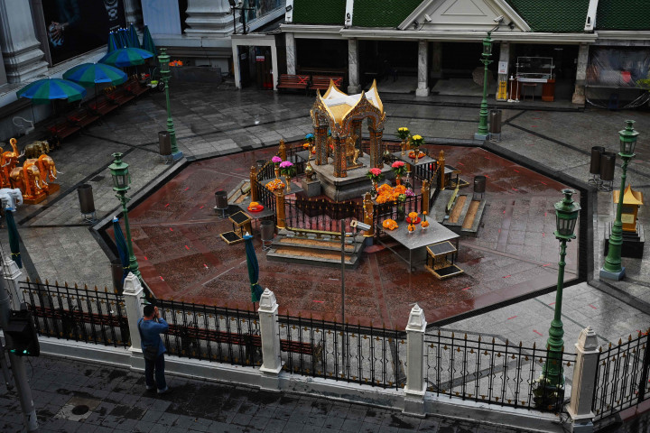 Seorang pria berdoa di luar gerbang Kuil Erawan pada hari pertama penguncian Covid-19 yang lebih ketat di Bangkok, Senin, 12 Juli 2021.