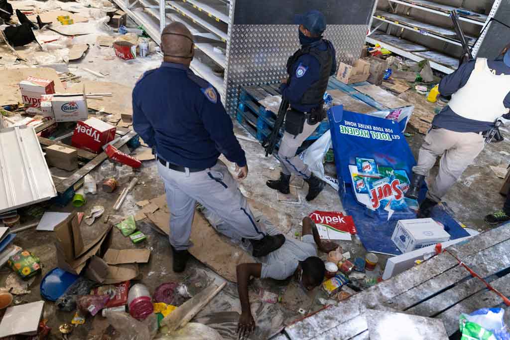 Anggota Polisi Afrika Selatan menangkap para penjarah di Pusat Perbelanjaan Gold Spot di Vosloorus, tenggara Johannesburg, pada Senin, 12 Juli 2021 waktu setempat.