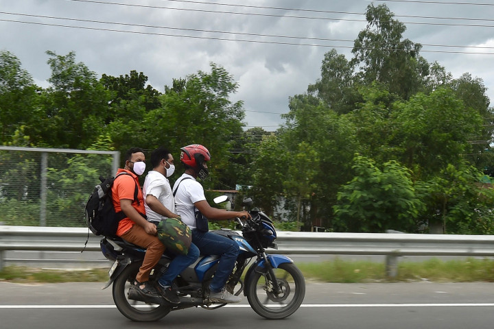 Orang-orang mengendarai sepeda motor menuju kampung halaman mereka setelah pelonggaran lockdown nasional Covid-19 di Sreenagar.